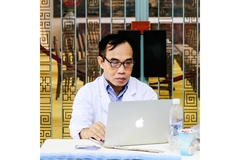 Image A doctor looks at a computer screen.
